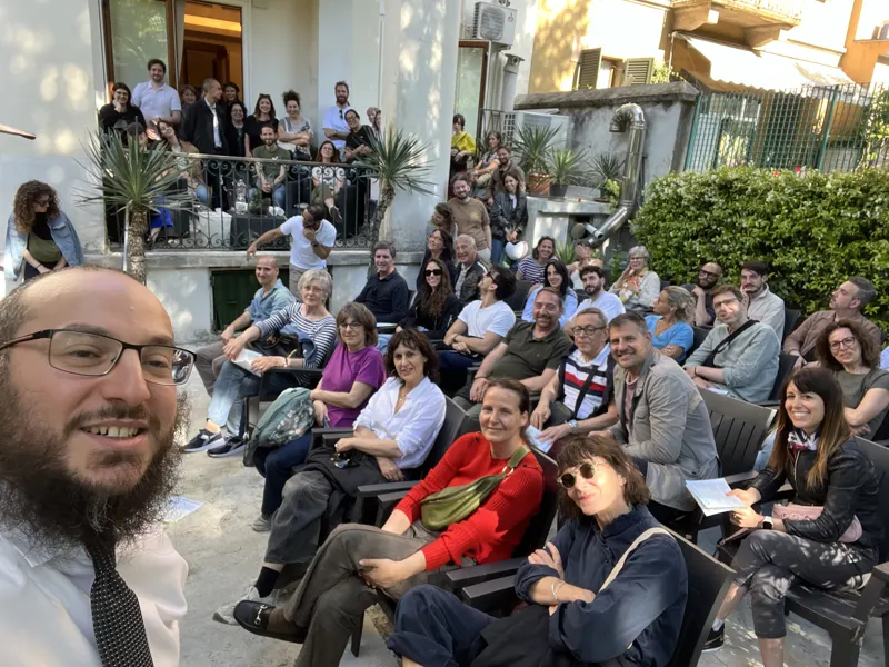 A large group listening to an Ambassador in a garden