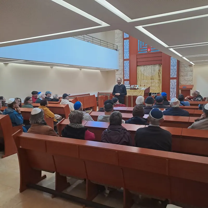 A group seated in a synagogue during a meeting