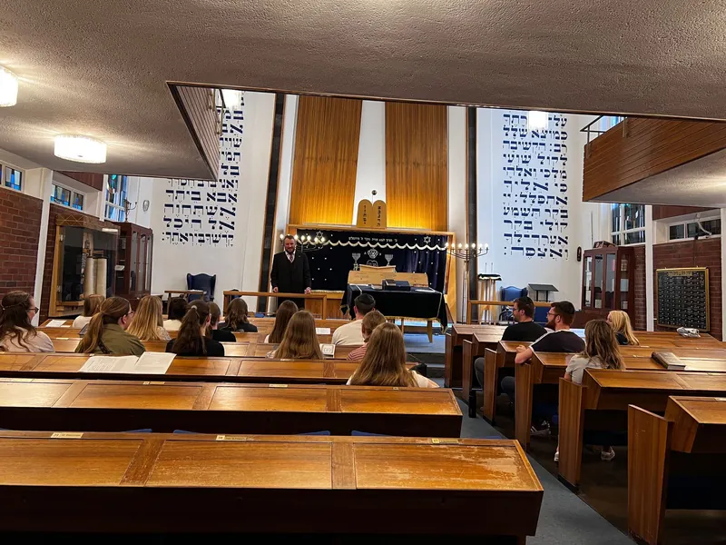 An Ambassador speaking to a group in a synagogue