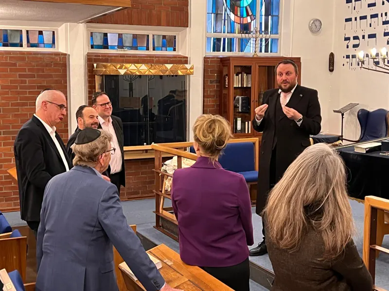 A rabbi guiding visitors in a synagogue
